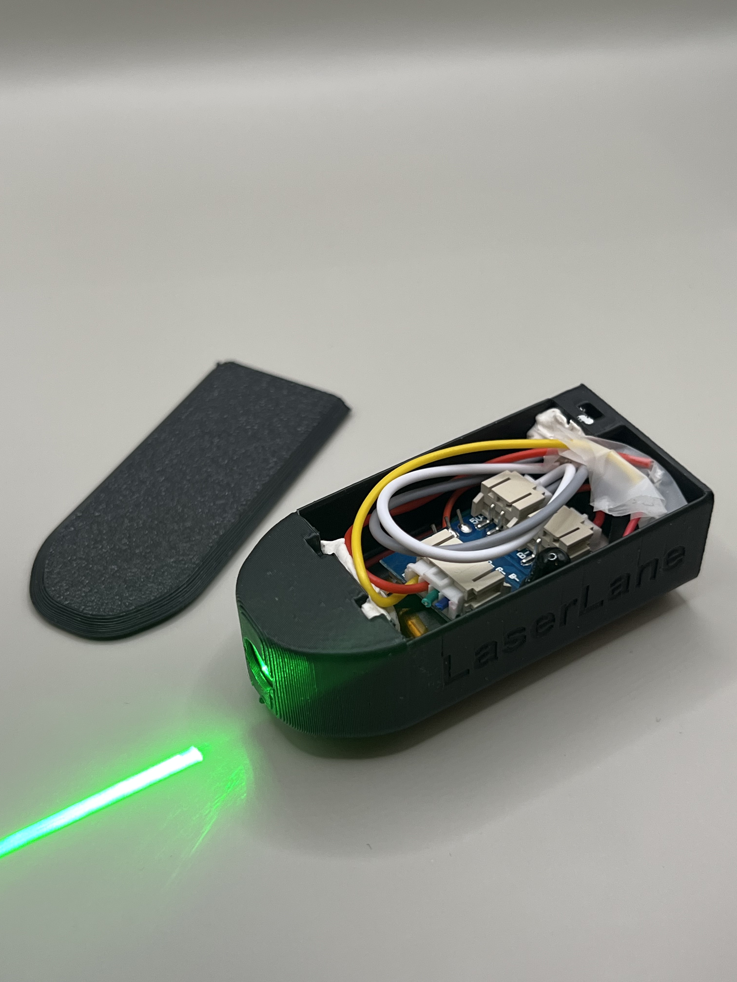 The 3D-printed LaserLane bike safety device projecting a green laser line